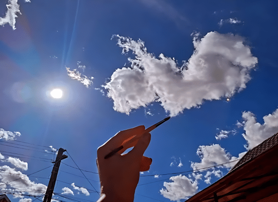 Let's connect! Foto van een hand met penseel die de wolken in de vorm van een hart tekent